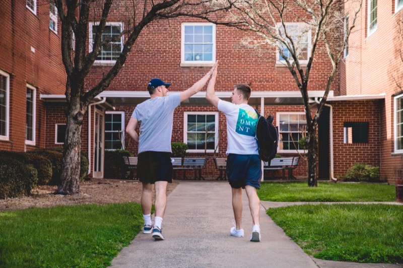 Students giving each other a high five while walking