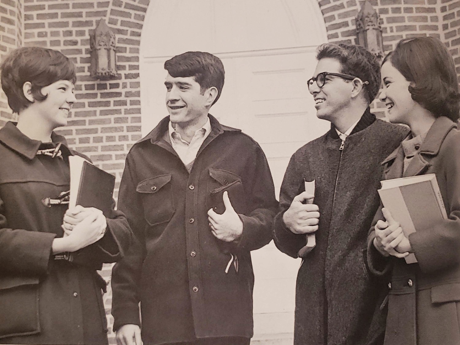 Student standing in front of building talking